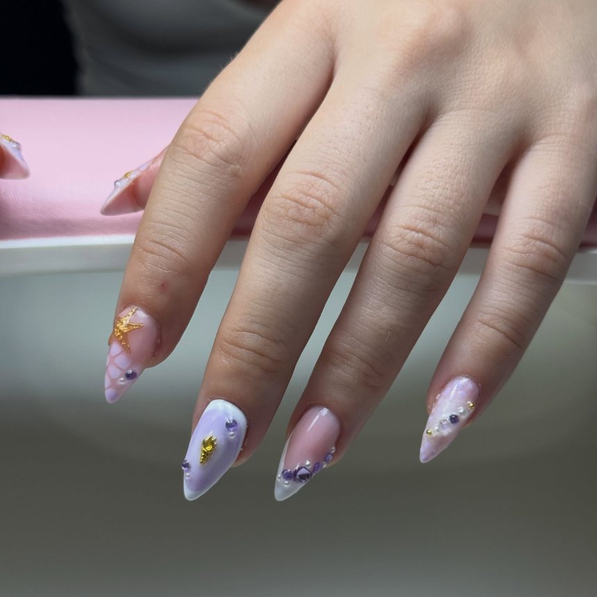 Ongles lilas avec étoile dorée et strass violets